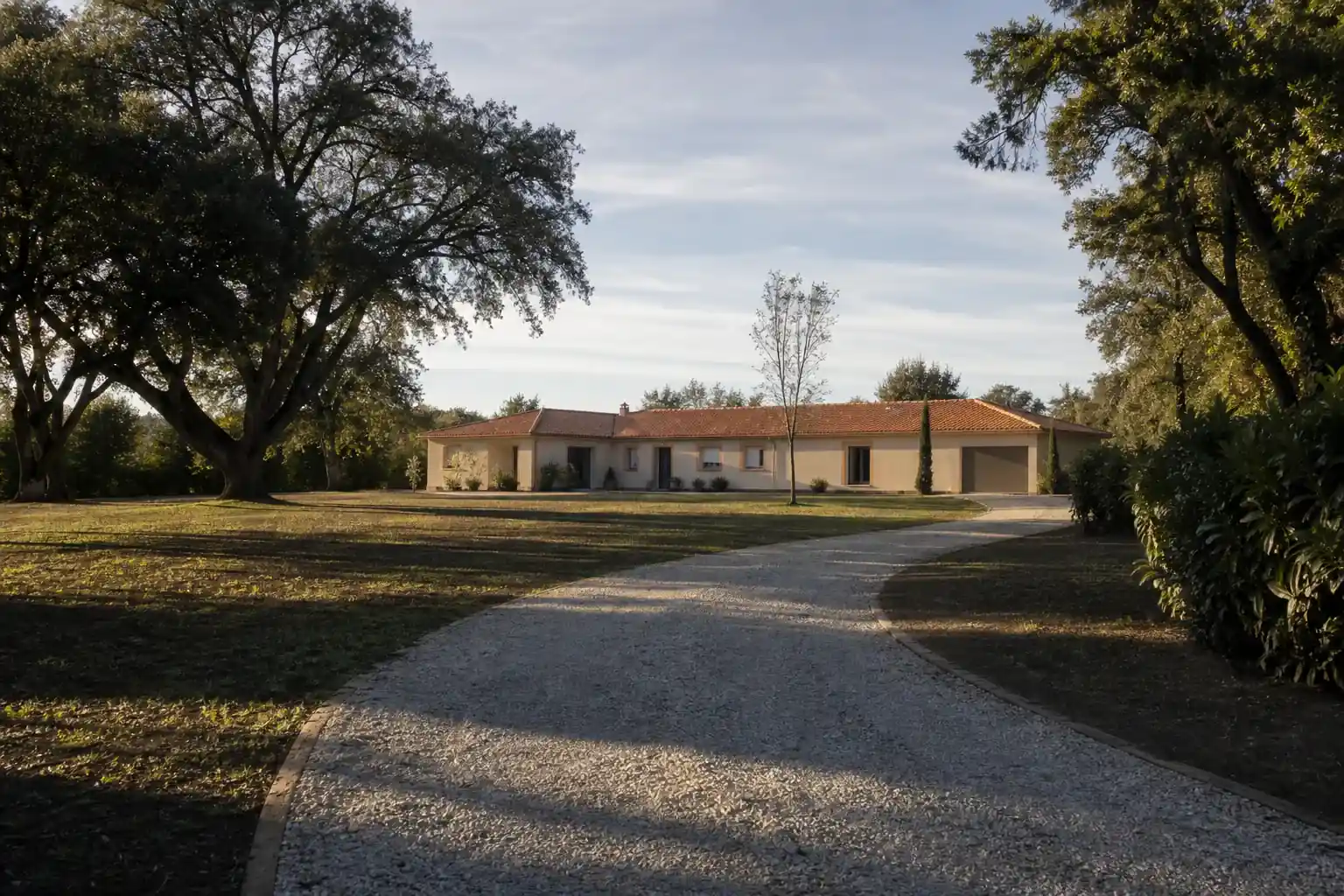 Terrain de belle largeur à l’ouest de Toulouse, maison de plain-pied très en retrait de la rue, chênes en limite et pelouse récemment semée